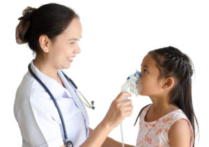 Nurse helps child with inhaler